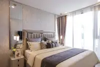 1 Bedroom Condo for Sale at Copacabana Coral Reef master bedroom with upholstered headboard, layered pillows and balcony access