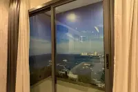 Studio Condo for Sale at Grand Solaire Noble sliding glass window with panoramic view of Pattaya Bay and city skyline