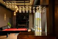4 Bedroom House for Rent in Bang Lamung bar area with hanging wine glasses, red billiard table, and dark feature wall