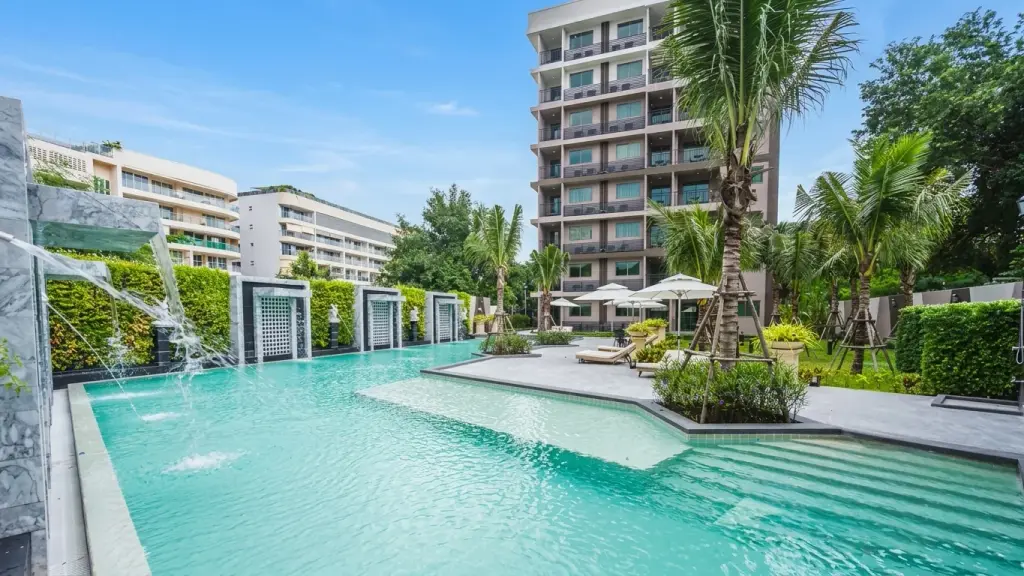 Arcadia Center Suite outdoor pool with water fountains, palm trees, and high-rise building view