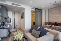 Studio Condo for Sale at Andromeda Condominium full open-plan interior with sofa, double bed, kitchen area, and sliding bathroom door