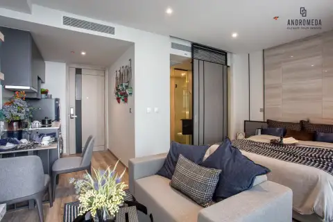 Studio Condo for Sale at Andromeda Condominium full open-plan interior with sofa, double bed, kitchen area, and sliding bathroom door