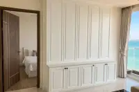 2 Bedroom Condo for Sale at Del Mare white wainscot wall with built-in cabinet, open bedroom door, and turquoise sea view