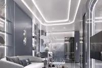 Studio Condo for Sale at Embassy World spacious living area with LED-lit ceiling, modern kitchen, sofa, and mirrored wardrobe panels