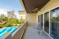 1 Bedroom Condo for Sale & Rent at View Talay Residence 1&2 private balcony with ceiling fan and wooden chairs overlooking the pool