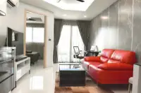 1 Bedroom Condo for Sale at Water Park living room with red sofa, glass balcony door, and bedroom view