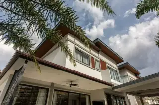 Zensiri Midtown Villas low-angle exterior view of two-storey facade with large windows, wood accents and palm tree framing