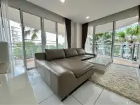 2 Bedroom Condo for Sale at Whale Marina living room with leather sectional sofa and balcony garden view
