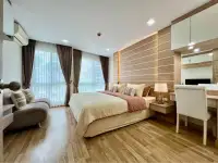 2 Bedroom Condo for Sale at Whale Marina bedroom with wood accent wall, king bed, and seating area