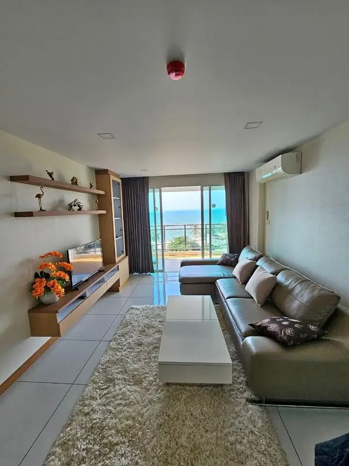 2 Bedroom Condo for Sale at Whale Marina living room with leather sofa, shag rug, and sea view balcony