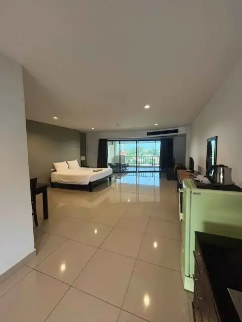 1 Bedroom Condo for Sale at Wongamat Privacy open-plan bedroom with king bed, tiled flooring and balcony access