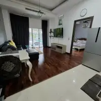 1 Bedroom Condo for Sale at Wongamat Privacy open living room with wood flooring, TV, and pool view through glass doors