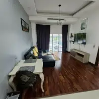 1 Bedroom Condo for Sale at Wongamat Privacy living area with leather sofa, dining table, and poolside sliding doors