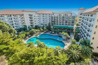 Wongamat Privacy resort-style condo complex with large lagoon pool, lush tropical landscaping, and surrounding buildings.