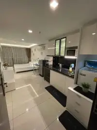 1 Bedroom Condo for Sale at Wongamat Tower open-plan studio with kitchen, bed, and tiled flooring