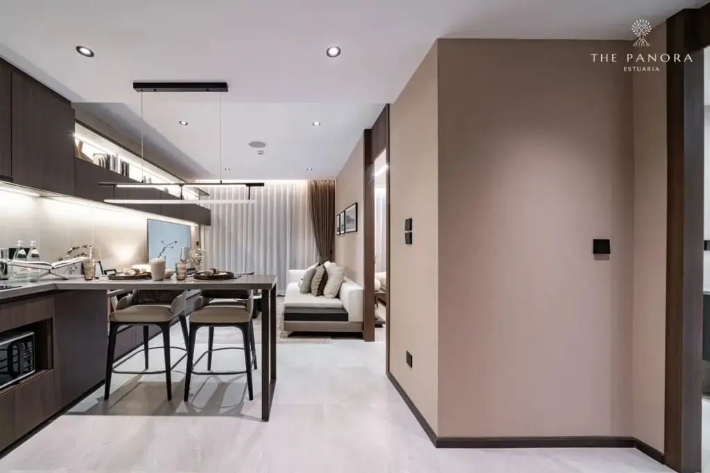 1 Bedroom Condo for Sale at Panora Estuaria: Open-plan living room with beige sofa, coffee table, and kitchen bar.