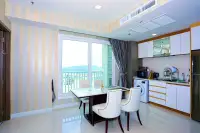 1 Bedroom Condo for Sale at Del Mare open-plan dining area and white kitchen with striped walls and balcony mountain view