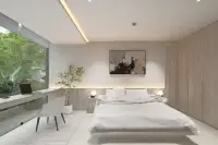 1 Bedroom Condo for Sale at Celine Wongamat spacious bedroom with platform bed, built-in wardrobe, desk area, and lush green garden view
