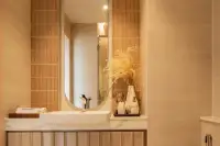Studio Condo for Sale at Seaspire Jomtien bathroom vanity with oval mirror, vessel sink, marble countertop, and terracotta tiles