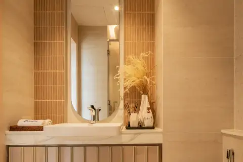 Studio Condo for Sale at Seaspire Jomtien bathroom vanity with oval mirror, vessel sink, marble countertop, and terracotta tiles