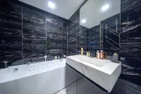 1 Bedroom Condo for Sale at Grand Solaire Noble luxury bathroom with black marble tiles, jacuzzi tub, and white vanity