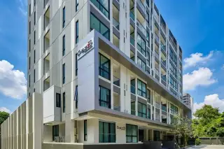 The Chezz Metro Life Condo modern exterior facade with large blue-tinted windows and balconies under a clear sky.