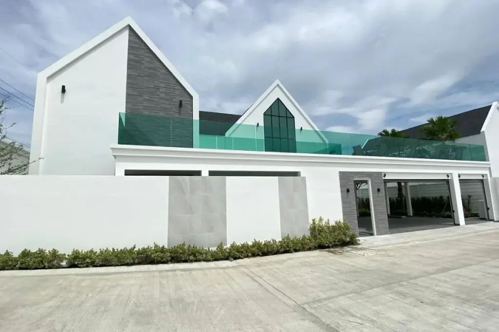 3 Bedroom House for Sale at Larelana Villa modern white exterior with grey stone accents and glass balcony.
