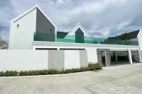 3 Bedroom House for Sale at Larelana Villa modern white exterior with grey stone accents and glass balcony.