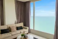 2 Bedroom Condo for Sale at Del Mare bright living room with beige sofa and floor-to-ceiling windows overlooking turquoise ocean