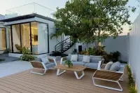 4 Bedroom House for Sale at AVANI Pool Villa outdoor lounge area on wood deck with mature tree and black steel staircase