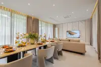 4 Bedroom House for Sale at Cascade open-plan dining area with large table, floral centrepiece and marble TV wall
