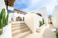 4 Bedroom House for Sale at The Sunshine House outdoor stairway flanked by tall cacti leading to pool area with thatched roof pavilion