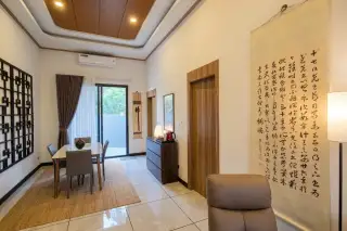 Amarin House 2 elegant dining area with wood-panel tray ceiling, Asian calligraphy decor, and sliding garden door