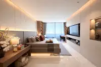 1 Bedroom Condo for Sale at Sea Sky By Sand luxurious bedroom with ambient LED lighting, marble floors, wooden desk, and white orchid decor
