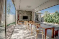 4 Bedroom House for Sale at Dhewee Resort open-plan living and dining area with large glass doors overlooking the pool.