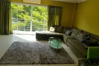 1 Bedroom Condo for Sale at Wongamat Privacy bright living area with L-shaped sofa, glass coffee table, and large balcony window with garden view