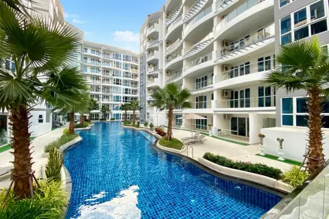 Grand Avenue Residence expansive swimming pool with a water slide, rock feature, and palm trees between condo towers.