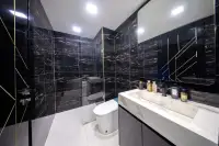1 Bedroom Condo for Sale at Grand Solaire Noble bathroom with black marble walls, marble vanity sink and glass shower enclosure