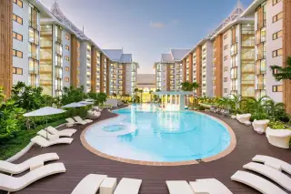 Wyndham Jomtien Pattaya large outdoor swimming pool with lounge chairs and surrounding condo buildings at sunset.