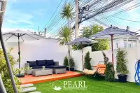 3 Bedroom House for Sale at Baan Pruksa Nara Chaiyapruek: outdoor patio with artificial grass, lounge set, and umbrellas.