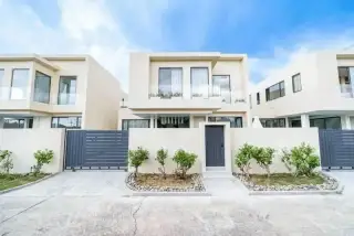 Young Life Villa backyard with swimming pool, fire pit, sun loungers, and lush green landscaping.