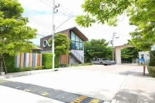 Supalai Ville Pattaya - Motorway clubhouse exterior with large glass windows and speed bump at entrance