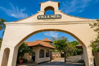 Villa Med entrance archway with property name, security gate, and guardhouse in Pattaya, Thailand.