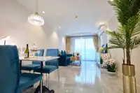 2 Bedroom Condo for Sale at Seven Seas Le Carnival dining area with marble table, blue chairs, and kitchen in background.
