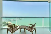1 Bedroom Condo for Rent at Movenpick Residences balcony with wooden chairs overlooking the marina and ocean.