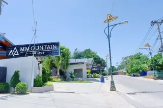 M Mountain Village entrance sign with landscaped garden and street view in Pattaya Thailand