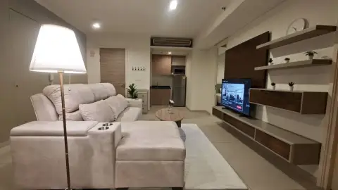 2 Bedroom Condo for Rent at Zire Wongamat open-plan lounge with TV wall unit and kitchenette