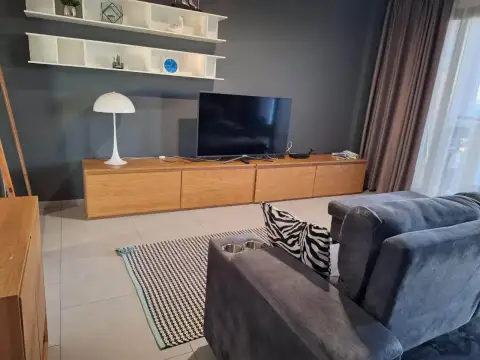 2 Bedroom Condo for Rent at Zire Wongamat entertainment unit with flat-screen TV, shelving and sofa seating