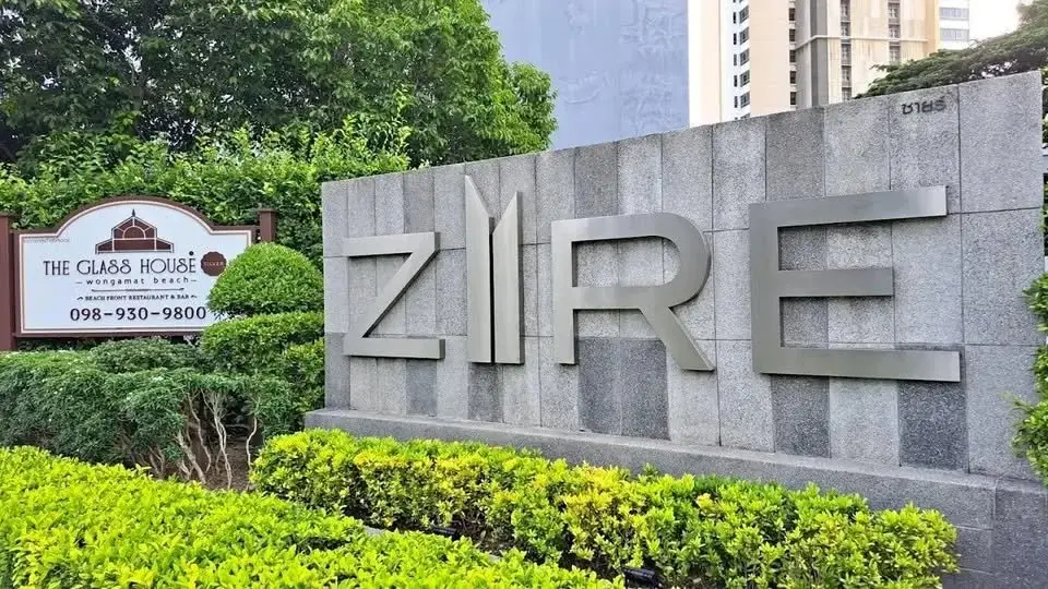 1 Bedroom Condo for Sale at Zire Wongamat entrance sign with stone wall and landscaped greenery