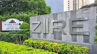1 Bedroom Condo for Sale at Zire Wongamat entrance sign with stone wall and landscaped greenery